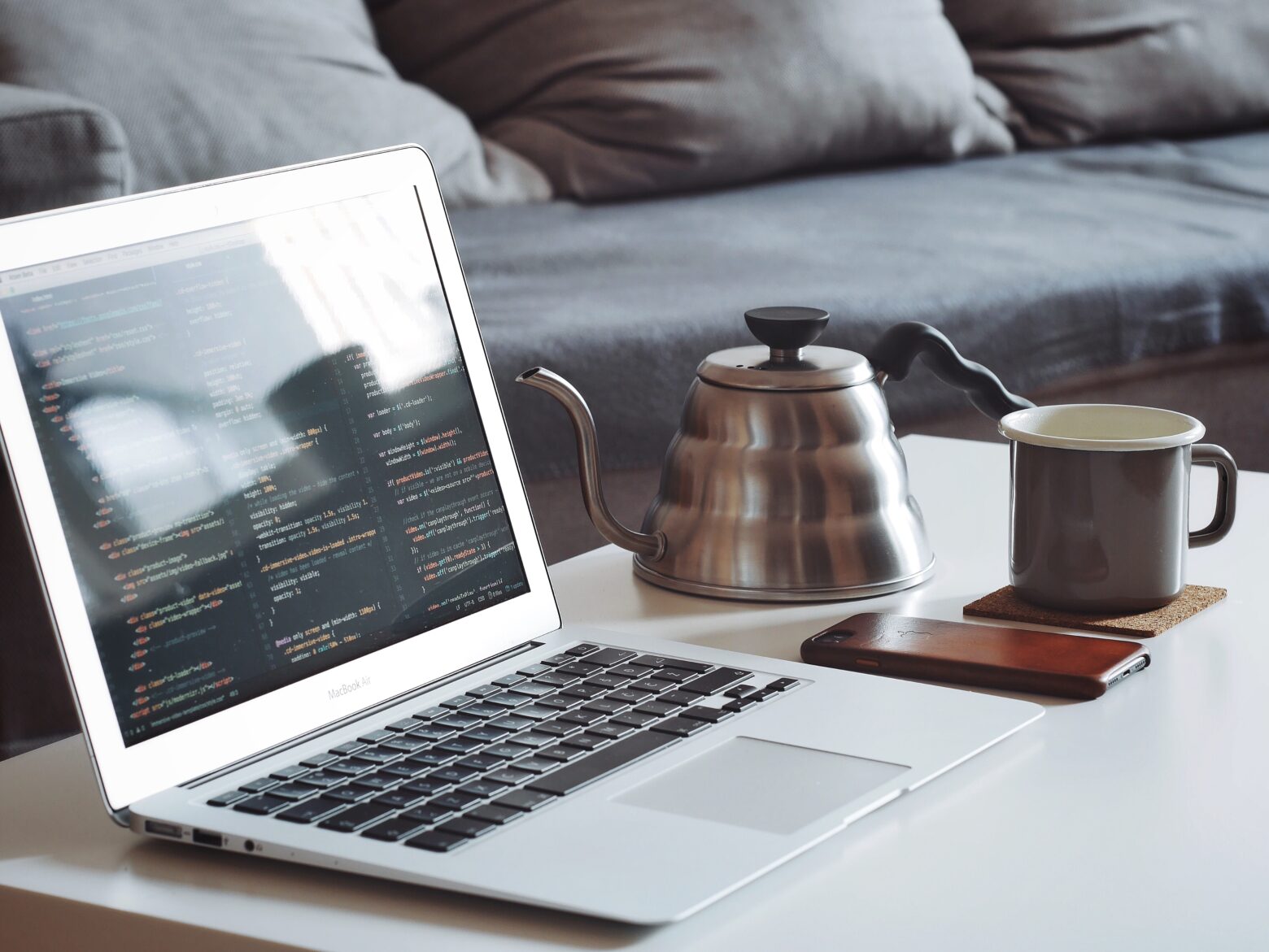 macbook and a cup of tea on the table